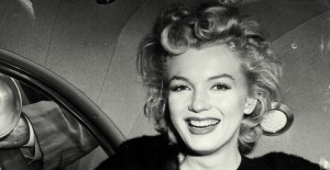 FILE - In this June 2, unknown year, file photo, actress Marilyn Monroe smiles in a car after arriving tousled from an all-night plane flight from Hollywood to Idlewild Airport, in New York. The actress said she planned to rest in New York before going to England to make a new movie with Sir Laurence Olivier. In late 2012, the FBI has released a new version of files it kept on Monroe that reveal the names of some of her acquaintances who had drawn concern from government officials and members of her entourage over their suspected ties to communism. (AP Photo, File)